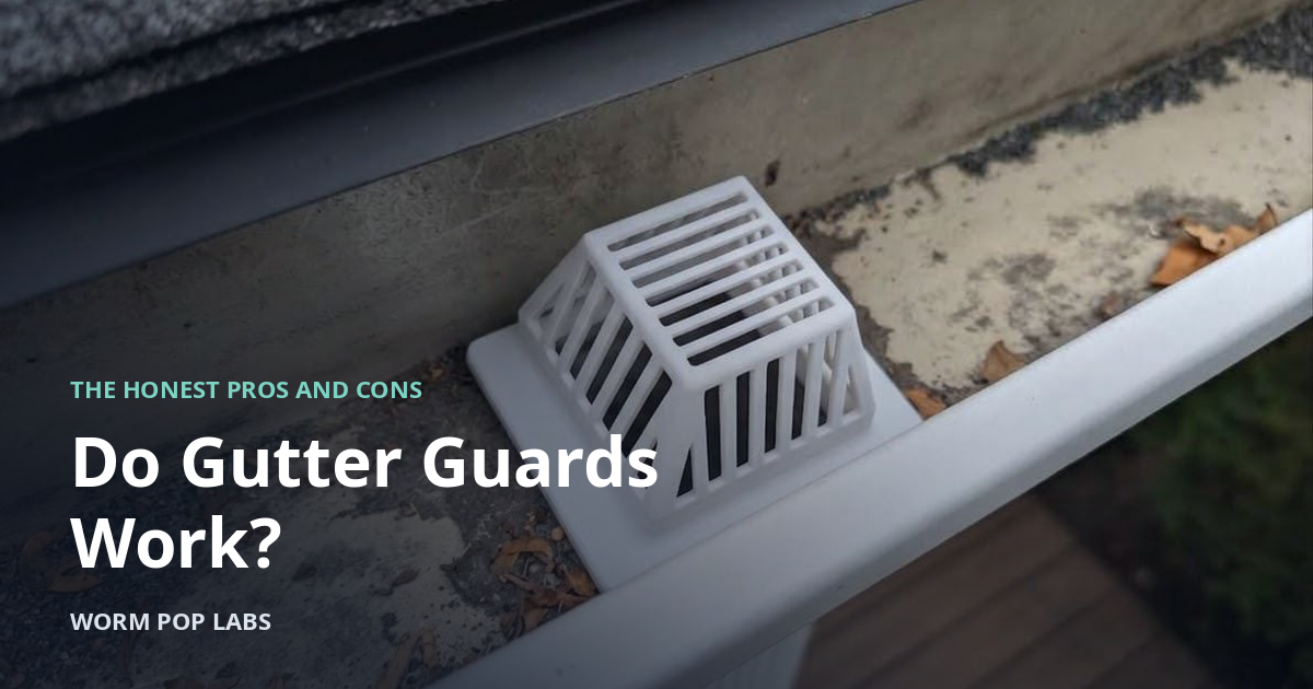 LeafEnemy downspout filter sitting over a gutter outlet, with dry leaves in the trough.