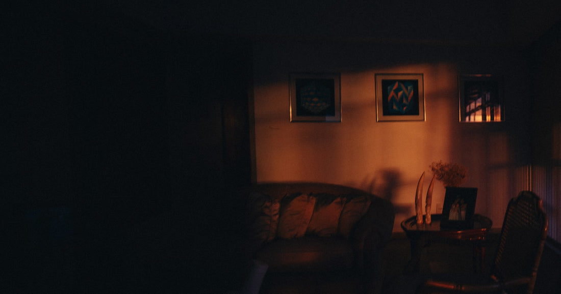 Dimly lit living room with framed wall art and warm ambient lighting for a Hisense Canvas TV style setup