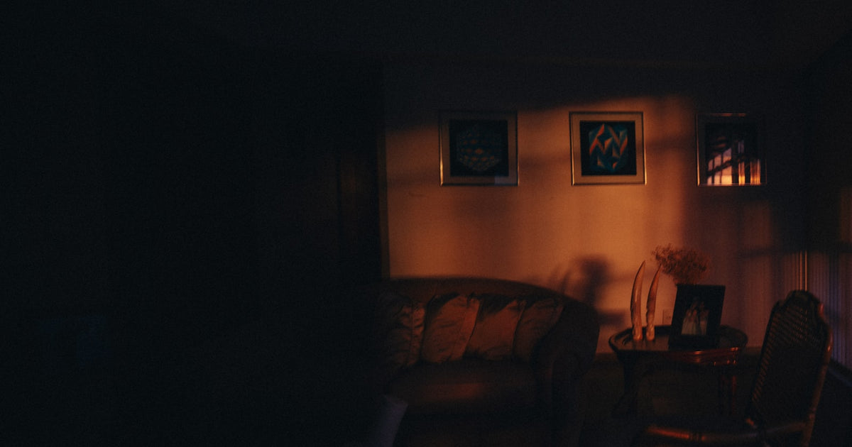 Dimly lit living room with framed wall art and warm ambient lighting for a Hisense Canvas TV style setup