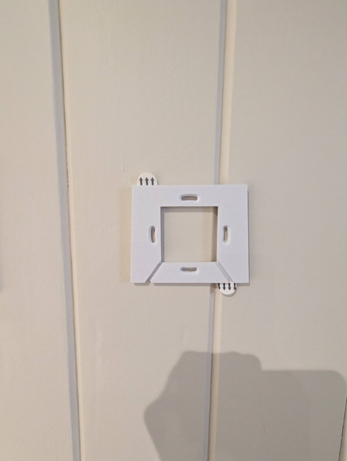 a white light switch on a white wall