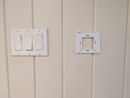 a light switch and outlet on a white wall