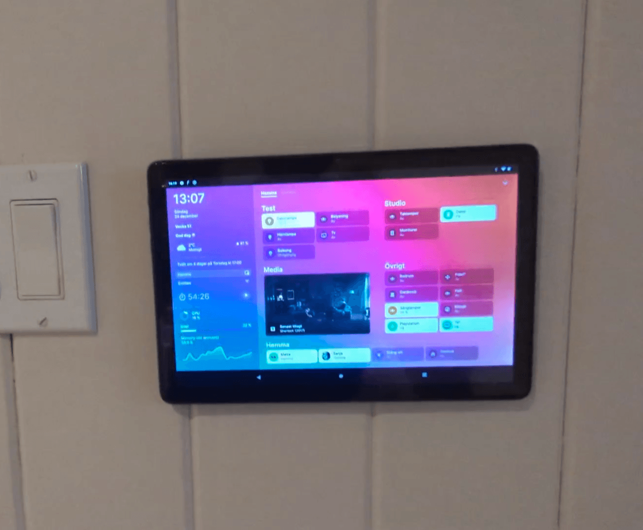 a tablet mounted on a wall with a light switch