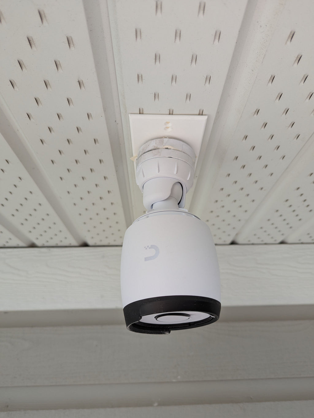 UniFi G6 Bullet camera mounted under a soffit on the white rectangular single-gang adapter plate